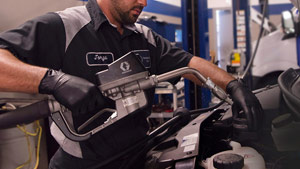 A mechanic servicing a Mercedes-Benz Van