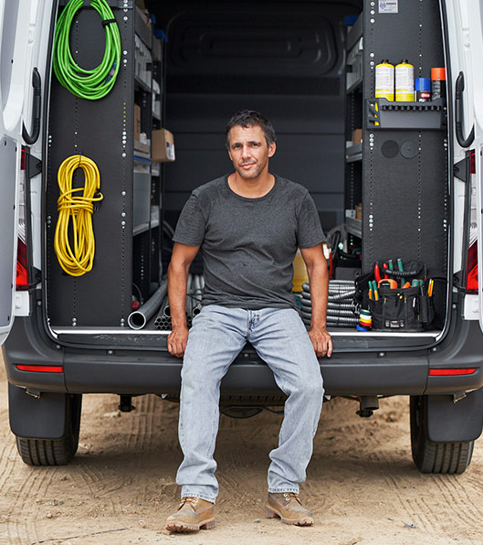 A man sitting on the back of an open Sprinter Cargo Van