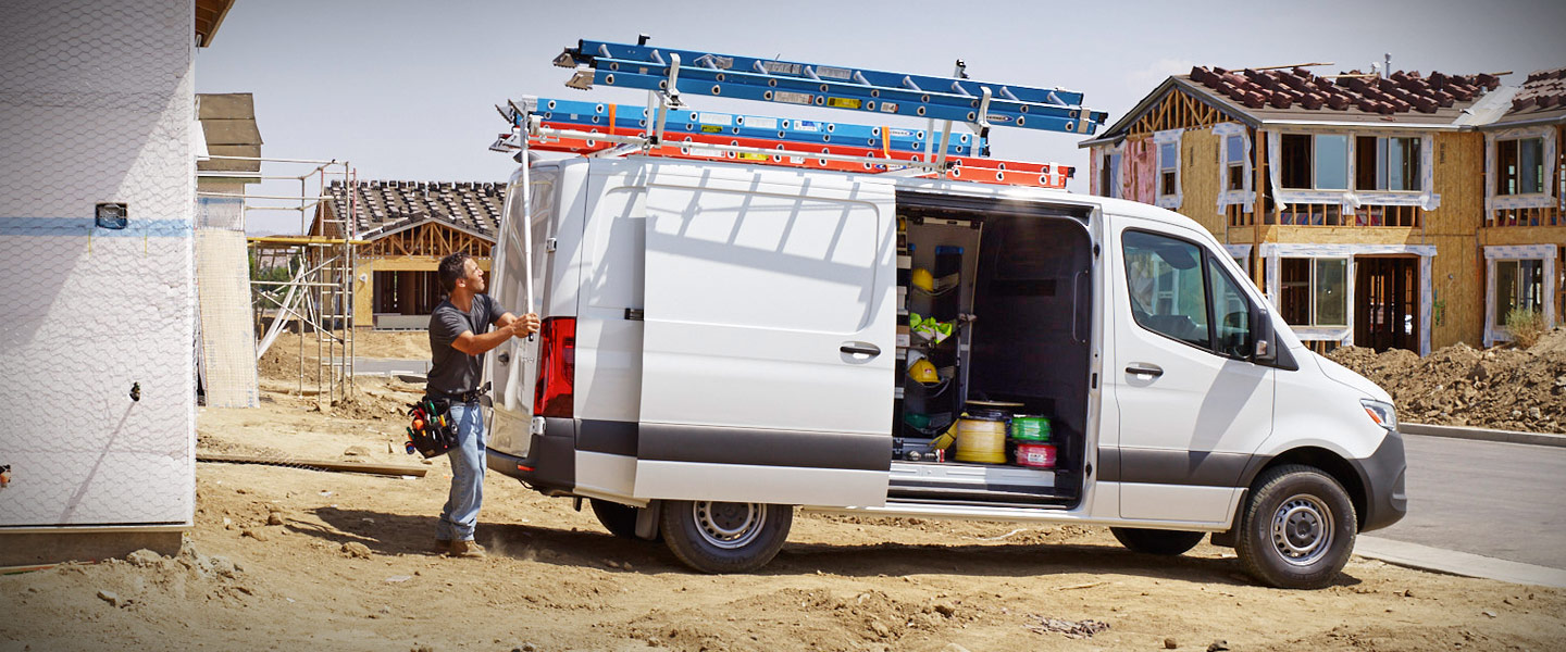 A man working from the back of a white Sprinter Cargo Van